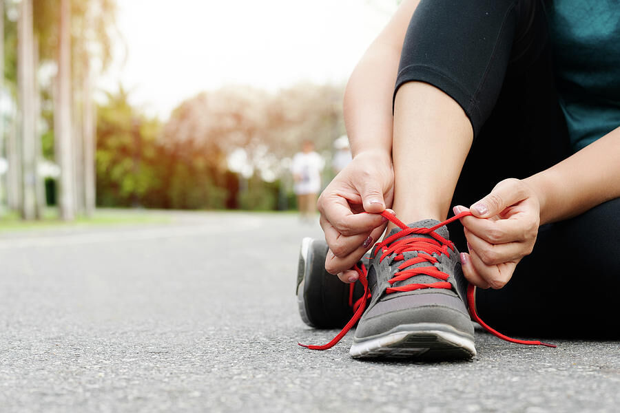 sport-woman-tying-shoelace-before-running-outdoor-activities-cavan-images