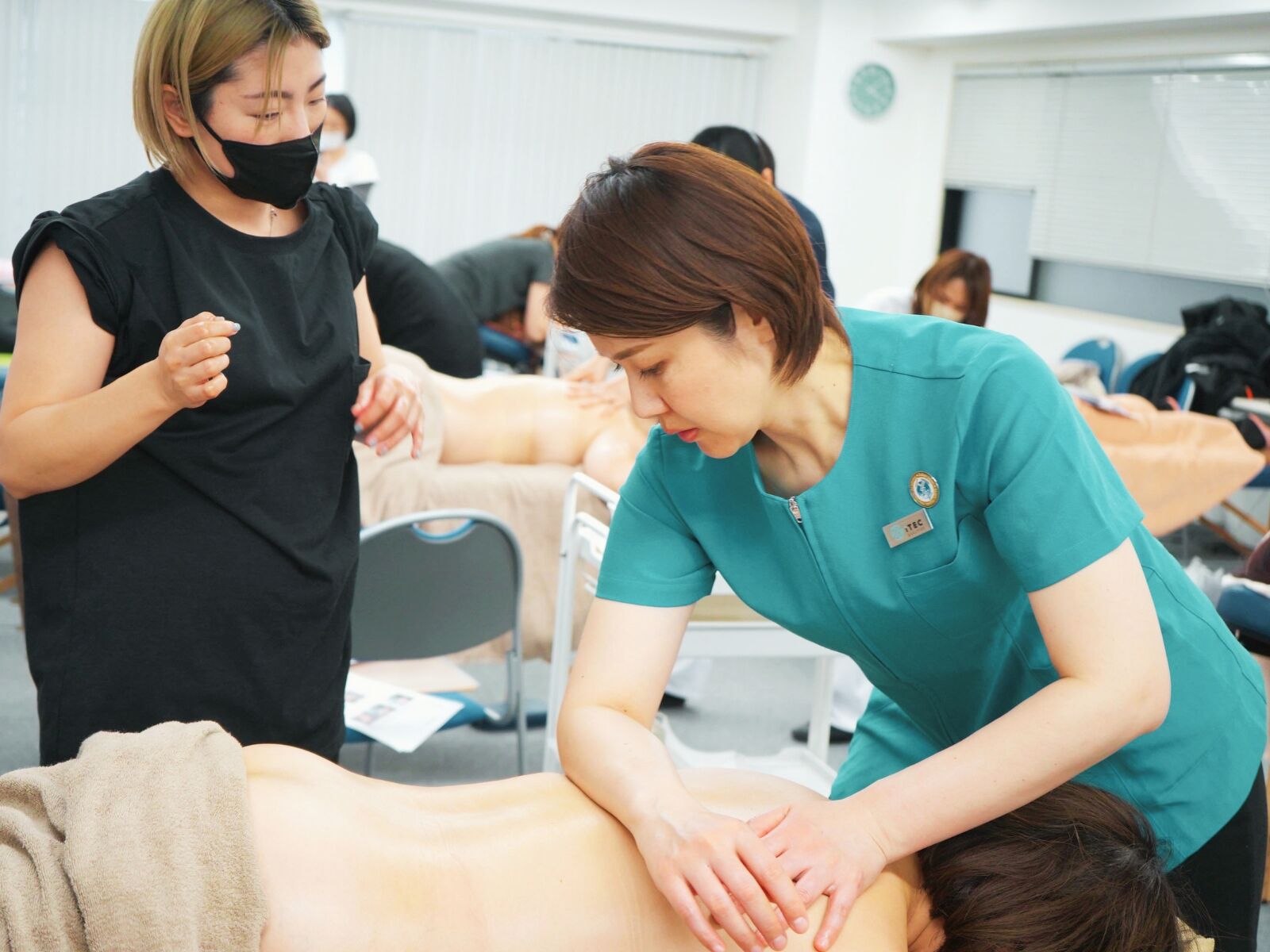 Instructor correcting a student's forearm and elbow technique during partner practice