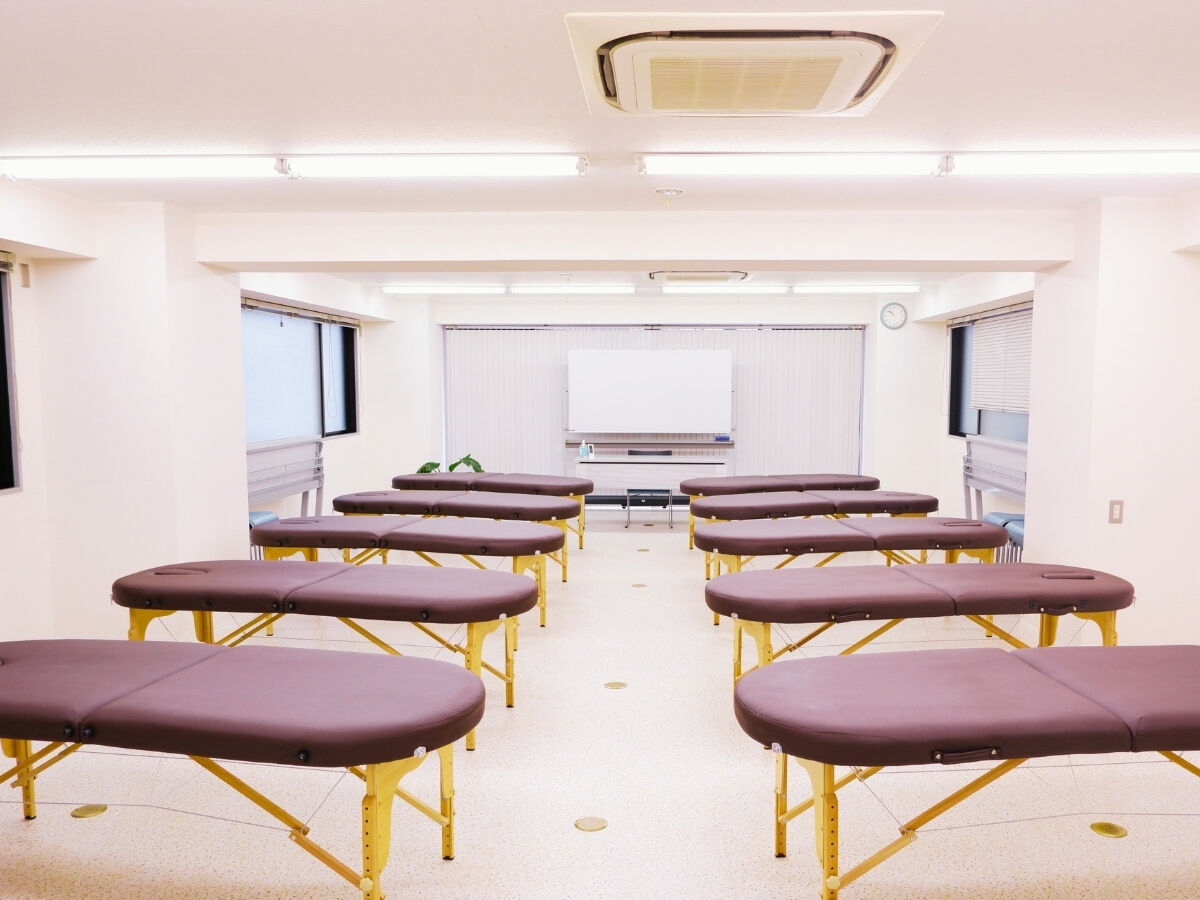 Interior of Room 2-A at Magic Hands Therapist Academy, set up with training tables for the course